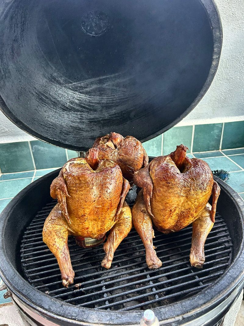 Twee hele kippen op de houtgestookte kamado-barbecue