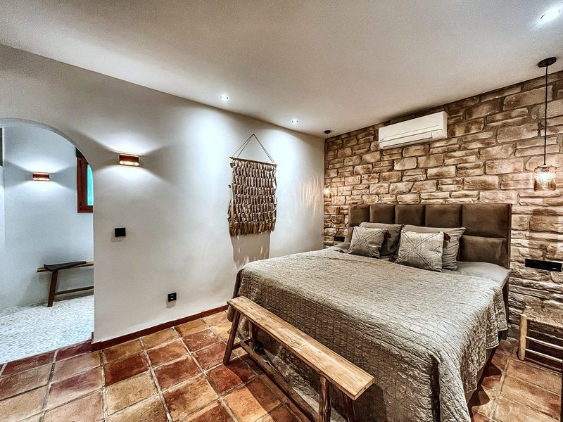 De slaapkamer van Appartement Oleander met natuurstenen wand