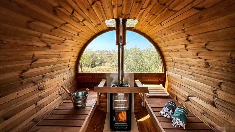 De houtgestookte sauna met rond raam en uitzicht over de olijfgaarden